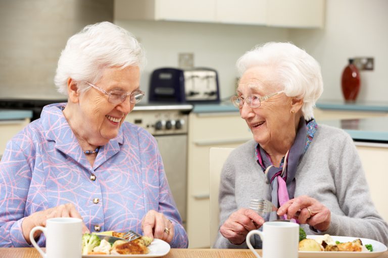 Senior Women Enjoying Meal Together At Home